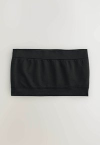 Haut bandeau noir extensible avec larges bandes élastiques en haut et en bas, posé à plat sur une surface claire.