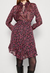 Abito floreale in tessuto trasparente nero con accenti rosa e viola, maniche lunghe, orlo a volant e scollatura con apertura a chiave e fiocco.