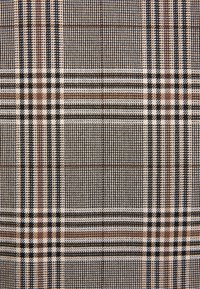 Mehrfarbiger karierten Stoff mit einer Mischung aus braunen, schwarzen und cremefarbenen Mustern, einer strukturierten Webart und einem Karodesign.