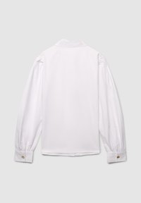 Camicia bianca a maniche lunghe con colletto classico, dettagli arricciati sulle spalle e polsini con bottoni. Tessuto morbido e leggero.