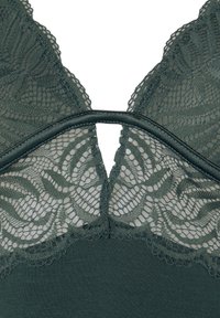 Bralette verde in pizzo con sovrapposizione in pizzo a motivo floreale sul retro, con spalline regolabili e base in tessuto liscio.