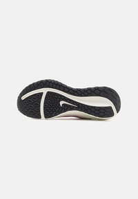 Podošva športovej topánky Nike, s textúrovaným čiernym gumovým vzorom, bielou medzipodrážkou a aerodynamickým tvarom so signature logom.