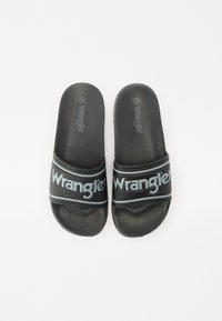 Sandale negre cu talpă antiderapantă, având o curea lată cu logo-ul "Wrangler" în nuanța albastru deschis, oferind un contrast și detalii interesante.