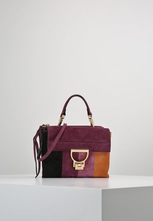 Lille rektangulær håndtaske i farveblokke i bordeaux, sort, pink og orange ruskind med guldspænde og enkelt top-håndtag, hvilende på hvid overflade.