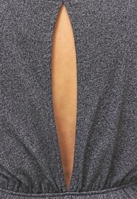 Prenda de color gris oscuro con una superficie texturizada, que presenta un corte vertical distintivo en la parte posterior. Cintura elástica para ajuste del fit.