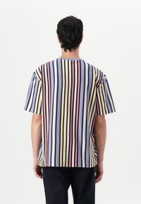 Striped short-sleeve shirt in soft cotton; features vertical stripes in blue, yellow, red, and black; relaxed fit and crew neckline.