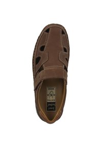 Brown leather shoe with open cutouts, stitched accents, and a wide fit. Lightly textured upper with a padded insole and flexible sole.