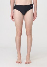 Slip da bagno neri con un design a vita bassa, caratterizzati da un logo arancione sul fronte. Il tessuto sembra liscio e aderente.