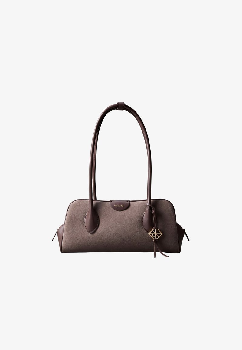 Καφέ τσάντα Calvin Klein από σουέντ και δέρμα με διπλές μακριές λαβές και χρυσό διακοσμητικό κρεμαστό στο δεξί μέρος.