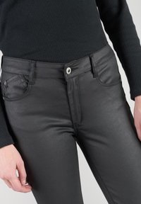 Pantaloni neri in ecopelle con vestibilità slim, dotati di tasche frontali, una texture lucida e una chiusura con bottone argentato in vita.