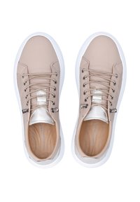 Beige Sneakers mit einer glatten Oberseite, weißer Gummisohle, metallisch silbernen Akzenten und klassischem Schnürverschluss. Texturierte Seitenpaneele sind enthalten.