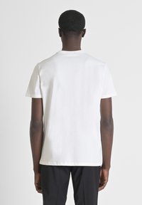 T-shirt bianco in cotone con taglio classico, maniche corte e colletto a girocollo. Il tessuto sembra liscio, senza loghi o fantasie visibili.