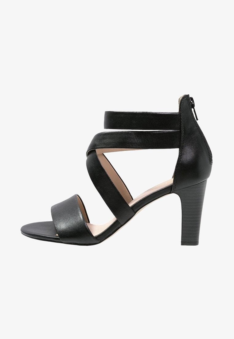 Sandale à talons hauts en cuir noir avec trois larges brides traversant le pied et une fermeture éclair arrière, vue de profil.
