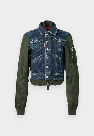 Orezaná bunda kombinujúca tmavý denim so zelenými nylonovými rukávmi, vybavená dvoma náprsnými vreckami, striebornými gombíkmi a rebrovaným lemom.