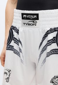 Λευκό αθλητικό σορτς με μαύρα γραφικά και σχέδια, με ελαστική μέση και ετικέτες με τη μάρκα "Venum" και "Tyson".