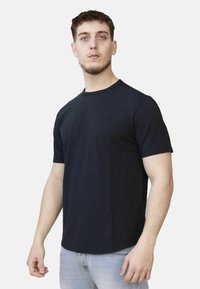 T-shirt nera in cotone con maniche corte e scollo rotondo, caratterizzata da una texture liscia e un design semplice. Silhouette aderente.