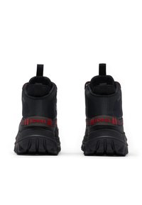 Bottines noires en matériau synthétique, avec des accents rouges, une semelle en caoutchouc texturée et des languettes à l'arrière pour un enfilage facile.