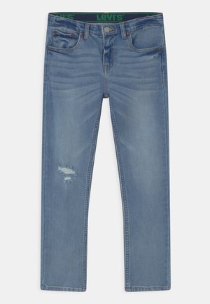 Jeans en denim bleu clair avec une coupe droite, présentant un détail usé au niveau du genou, cinq poches et une ceinture de marque verte.