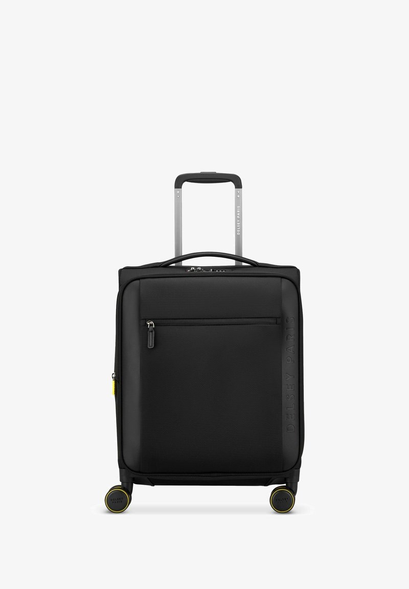 Valise rigide noire avec une surface texturée, une poche frontale zippée, une poignée extensible et quatre roues avec des accents jaunes pour la mobilité.