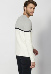 Maglione a maniche lunghe a righe grigie e bianche in maglia, con tessuto testurizzato, caratterizzato da una striscia orizzontale blu navy sulla parte superiore del petto.
