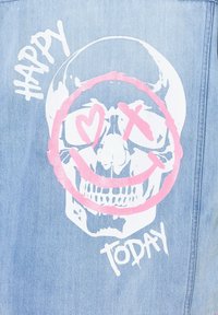 Tissu en denim bleu clair présentant un grand design graphique d'une tête de mort avec des accents roses et le texte "HEUREUX" et "AUJOURD'HUI."