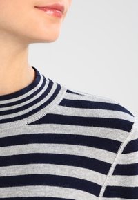 Gestreifter Pullover in Grau und Marineblau mit hohem Kragen, weicher Textur und geripptem Halsdesign mit gleichmäßigen horizontalen Streifen.