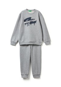 Šedá souprava mikiny a tepláků s logem "BENETTON" v bílé barvě přes černý design ve tvaru štětce na přední straně mikiny.