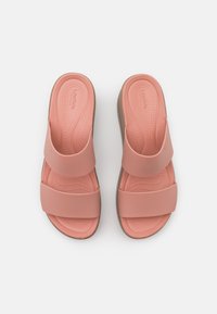 Paire de sandales roses à enfiler avec deux larges brides et une semelle texturée, vue de dessus sur fond blanc.
