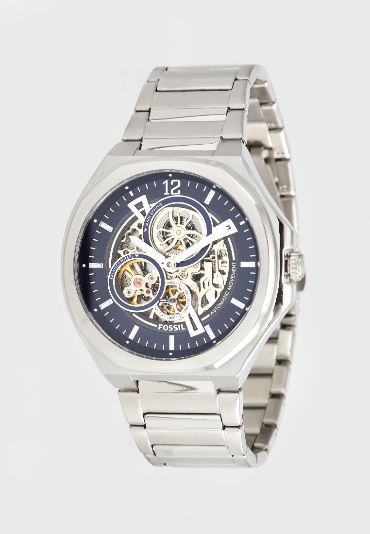 Silver stainless steel watch with a navy blue dial, skeleton movement, and octagonal case. Features luminescent hands and markers.