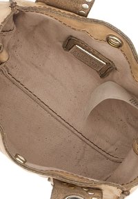 Interno di borsa in pelle beige con fodera in tessuto liscio, dettagli in metallo dorato e cuciture rifinite. Etichetta visibile su un lato.