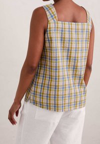 Top senza maniche in lino a quadri con scollatura quadrata nelle tonalità di blu, giallo e bianco. Presenta una vestibilità rilassata e spacchi laterali.