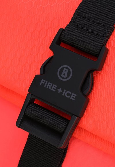 Röd tyg med hexagonmönster och en svart plastspänne. Spännet har texten "FIRE+ICE" och en cirkulär logotyp i mitten.