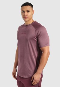 Krátký rukáv sportovního trička v tmavě mauve, texturovaná tkanina, s kulatým výstřihem a jemným logem tištěným na přední straně.