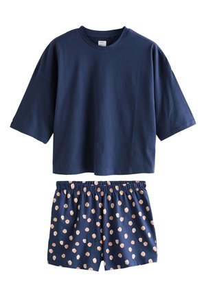 T-shirt bleu marine à manches courtes associé à un short bleu marine à taille élastique avec un motif à pois roses clairs dispersés.