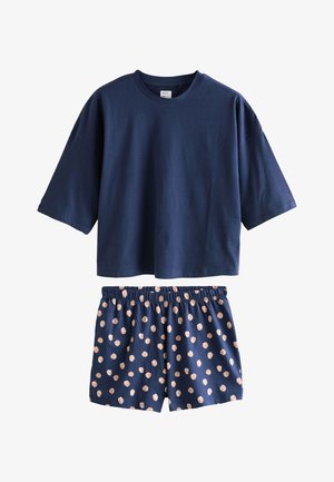 Tmavomodré tričko s krátkym rukávom v kombinácii s tmavomodrými elastickými šortkami so vzorom roztrúsených svetloružových bodiek.