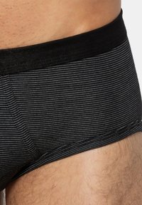 Zwarte boxer briefs met strepen, voorzien van een zachte, elastische tailleband. De stof heeft een gladde textuur met dunne horizontale strepen.