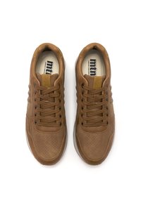 Un par de zapatillas de cuero marrón con puntera perforada, cordones a juego y plantillas acolchadas etiquetadas "mtn" sobre fondo blanco.