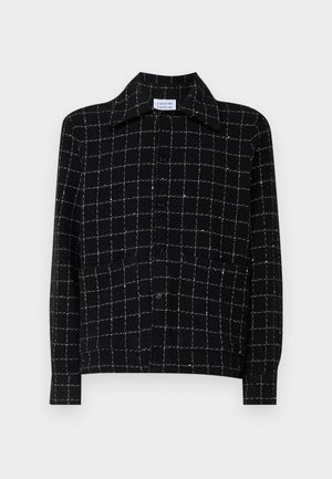 Svart skjorte med knapper og et stort rutemønster i hvite linjer, med klassisk krage og lange ermer, laget av teksturert stoff.