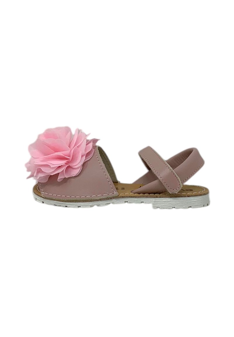 Sandali rosa con un grande fiore di tessuto rosa sulla punta, suola piatta bianca e una cinghia regolabile alla caviglia. Materiale simile alla pelle liscio.