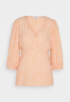 Blouse pêche avec un col en V, manches 3/4 froncées et motifs abstraits blancs. Tissu léger avec une coupe décontractée. Détail de taille élastique.