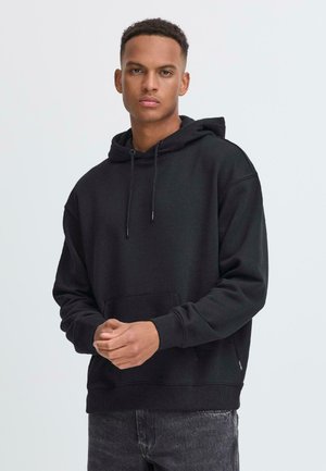 Haut à capuche noir avec une grande poche avant, cordons de serrage au cou, poignets côtelés et coupe décontractée. Tissu en coton, texture lisse.