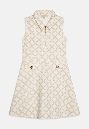Ærmeløs kjole i cremefarve med et mønster af guldkæder, udstyret med en krave, en forreste lynlås og to påsyede lommer med guldknapper.