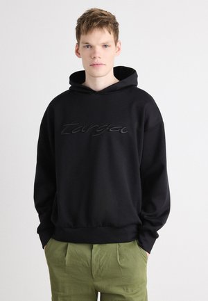 Zwarte hoodie van zachte stof met een verhoogd, reliëflogo op de borst. Ontspannen pasvorm met een buidelzak en ribgebreide manchetten.