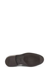 Sole di scarpa in pelle marrone con una texture liscia, caratterizzata da un motivo rigato per la presa e un bordo cucito lungo il perimetro.