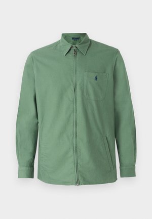 Giacca in cotone verde con zip frontale, colletto con bottoni e tasca sul petto con logo. Taglio dritto e maniche lunghe.