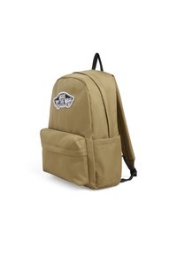 Zaino beige con superficie texturizzata, dotato di una tasca frontale e di un'etichetta con logo "Vans". Sono visibili due spallacci neri.
