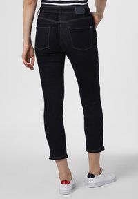 Mörkblå denimjeans med slim fit, medelhög midja och uppvikt fåll. Har bakfickor och kontrasterande sömmar.