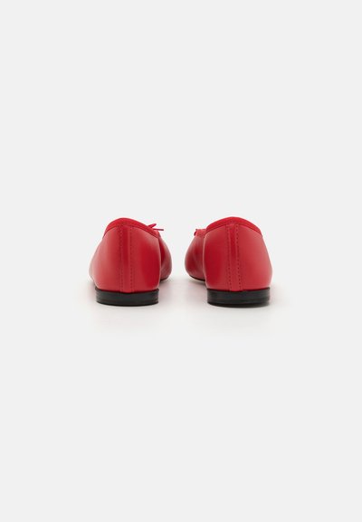 Red leather ballet flats with a rounded shape, low black heel, and matching stitched seams. Soft, smooth texture with minimal embellishments.