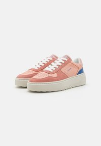 Baskets en suède et cuir rose avec des lacets blancs, bout perforé et semelle beige. Présente un accent bleu au niveau du talon et un logo sur la languette.