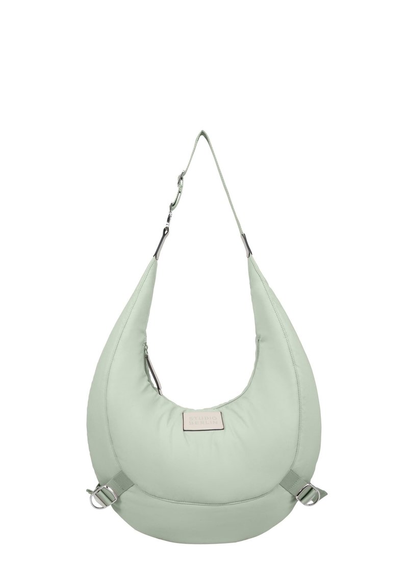 Borsa a spalla verde, imbottita, con forma a mezzaluna, tracolla regolabile, componenti in metallo e etichetta frontale. Texture morbida e design minimalista.